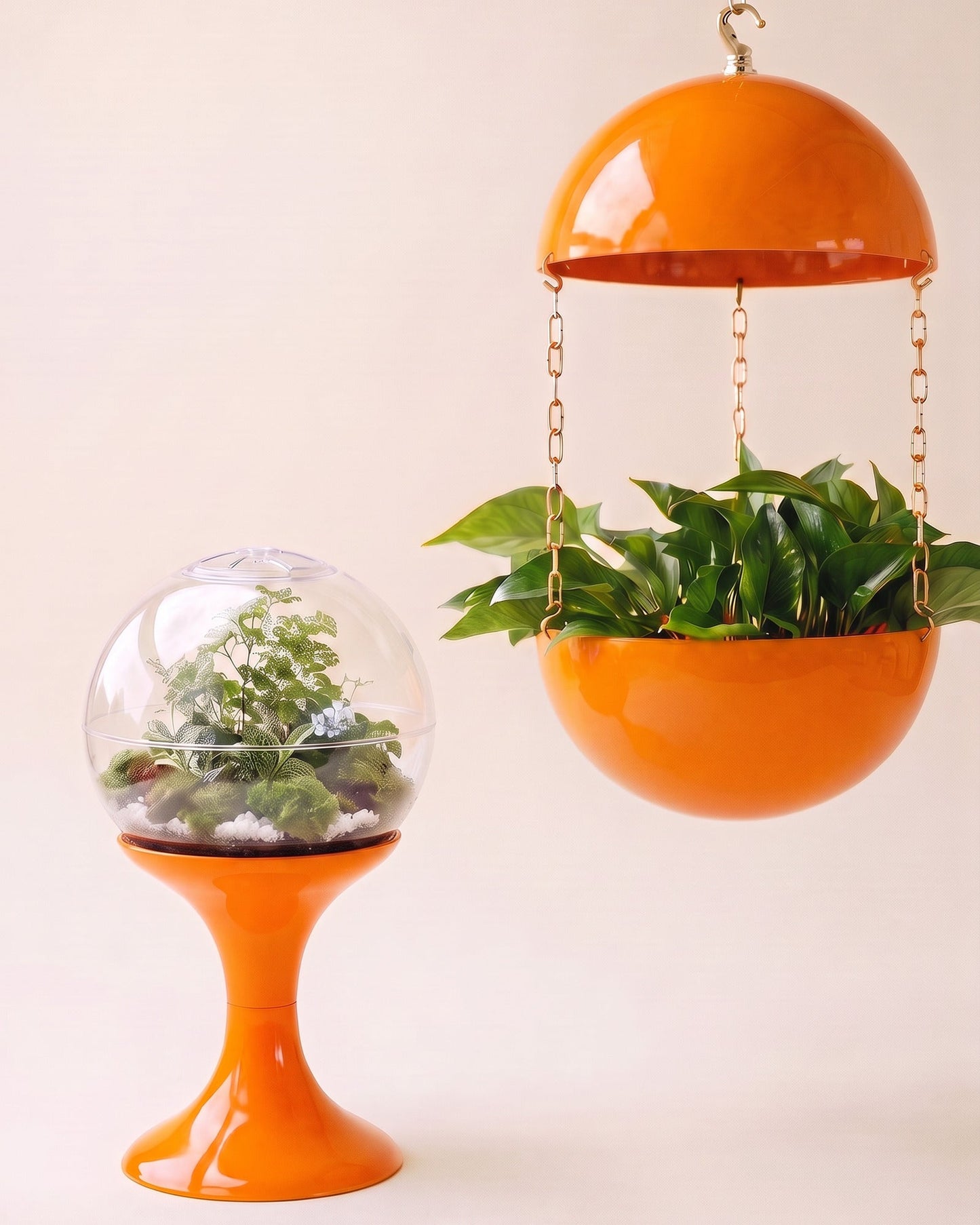 Matched Solar Orange pair: an orange terrarium beside an orange pendant planter suspended on a brass chain, on a plain cream studio field