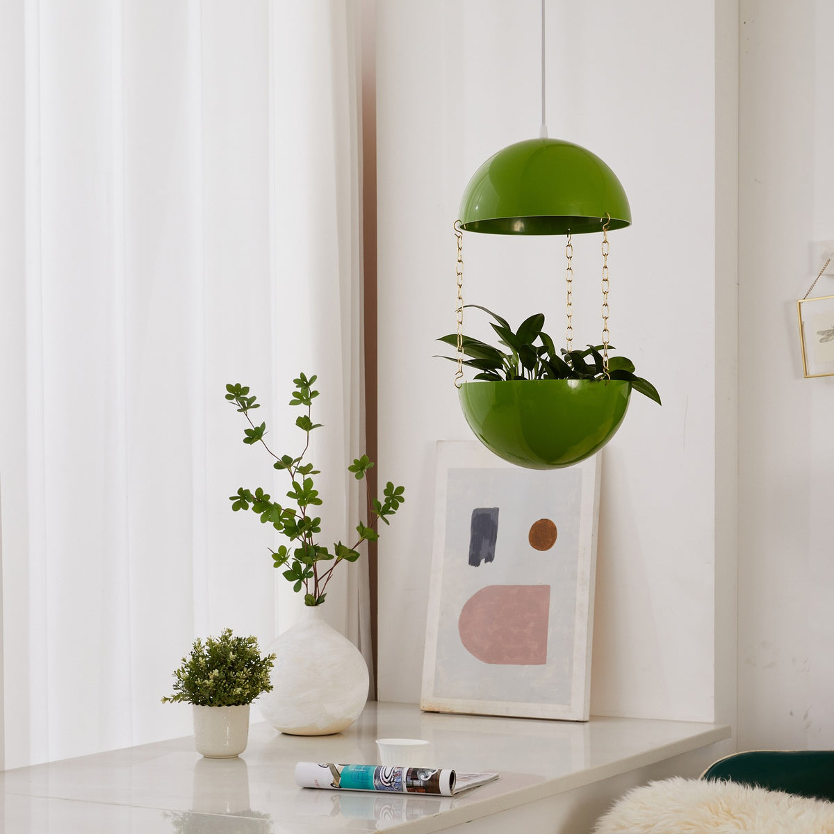 Atomic Green Potifiv Pendant Planter with a trailing plant, hanging in a mid century modern interior