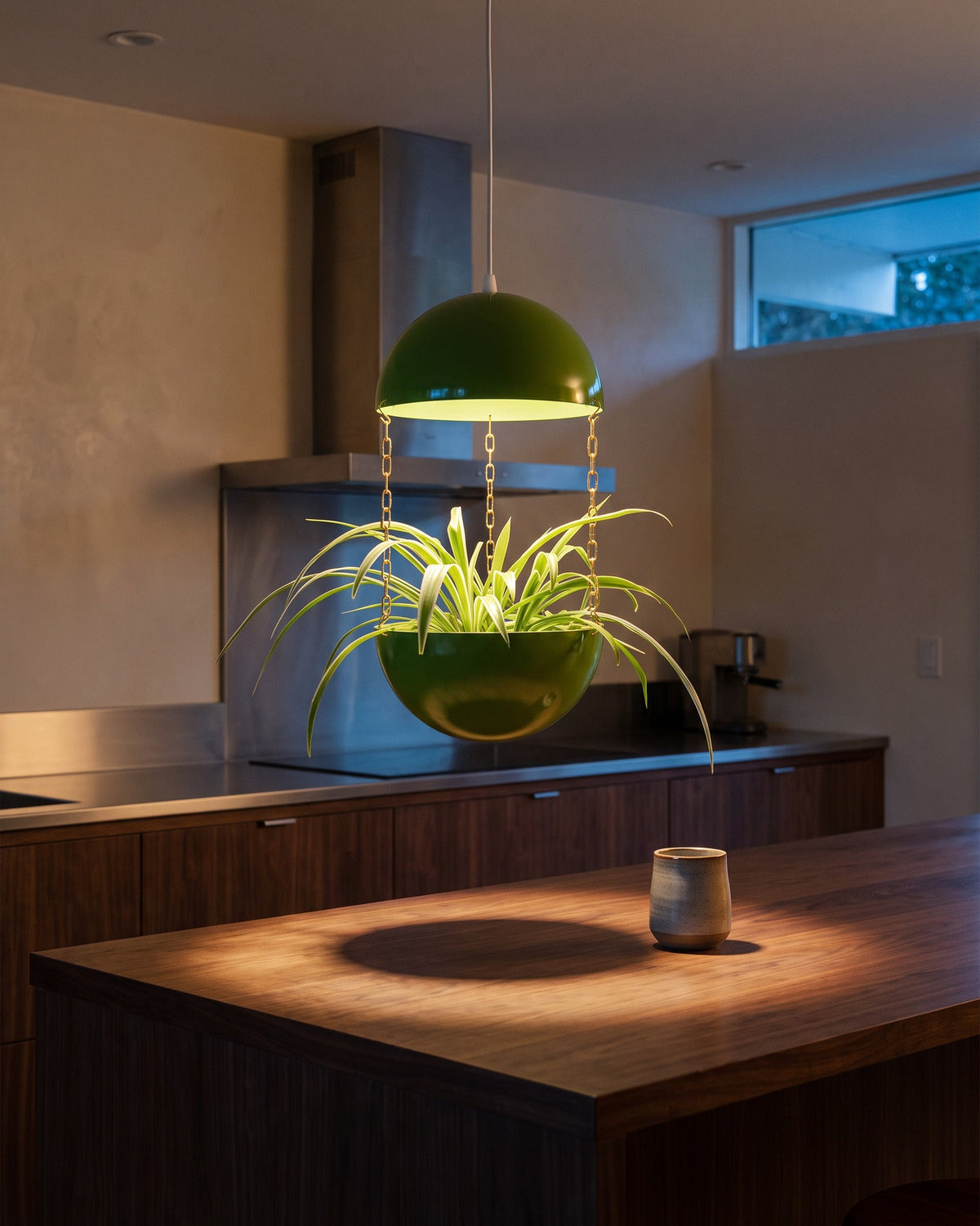 Atomic Green Potifiv Pendant Planter casting a pool of warm light down onto a kitchen island counter at dusk